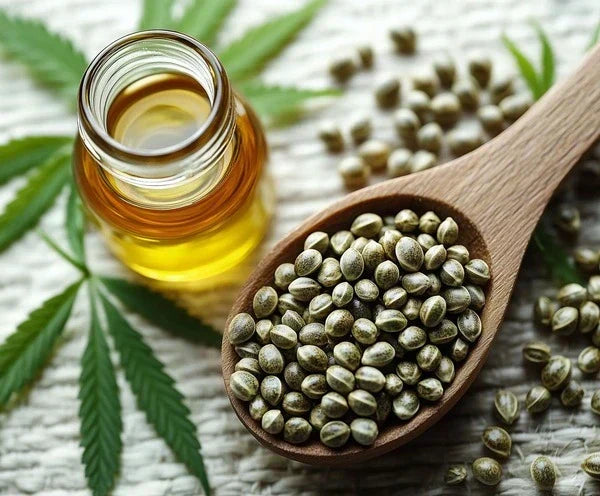 CBD Samen auf einem Holzlöffel neben Hanfblatt und CBD Öl