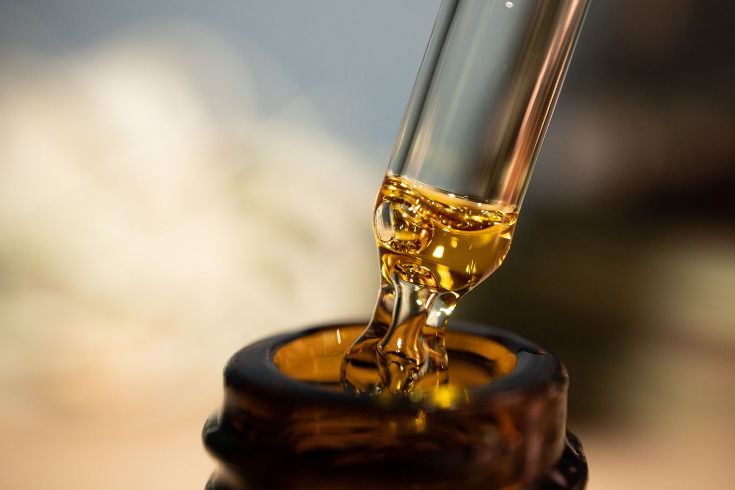 CBD Öl wird mit einer Pipette aus einer Braunglasflasche entnommen