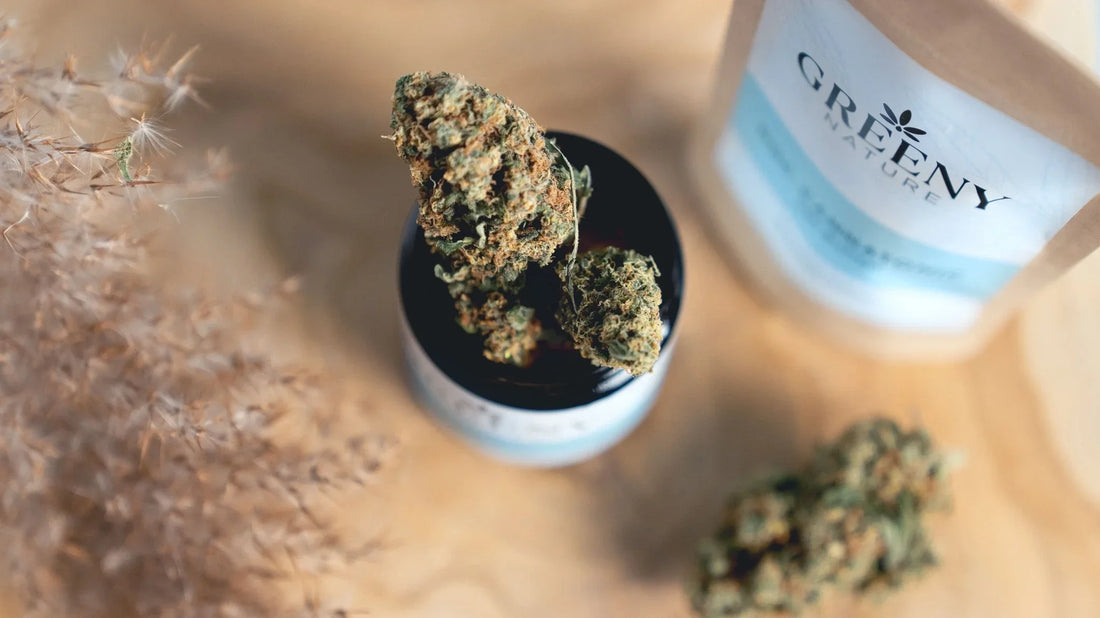 GreenyNature Saphir Kush CBD Blüten im geöffneten Glastiegel auf einem Holztisch