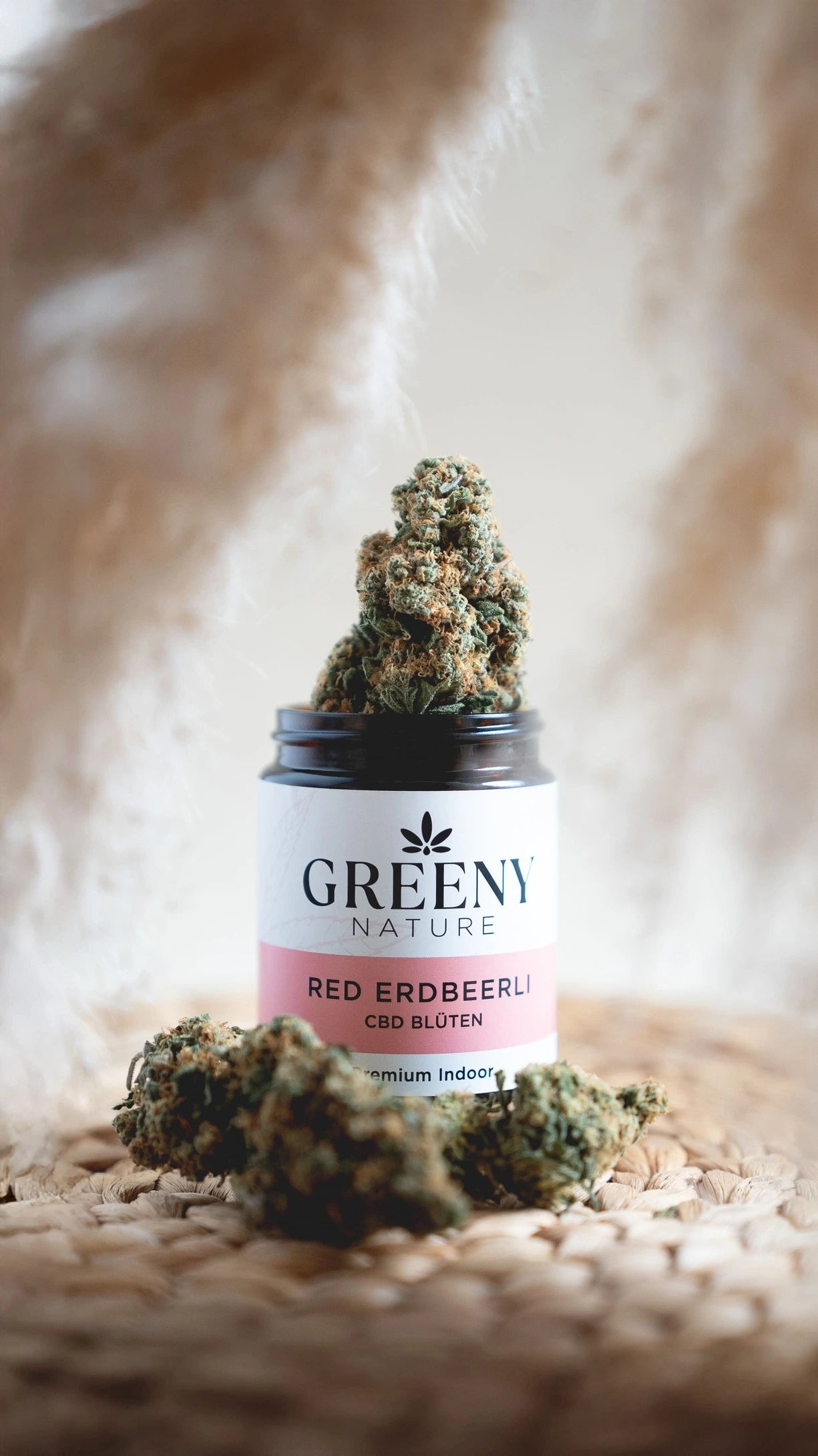 GreenyNature CBD Blüten im geöffneten Glastiegel neben weiteren Blüten