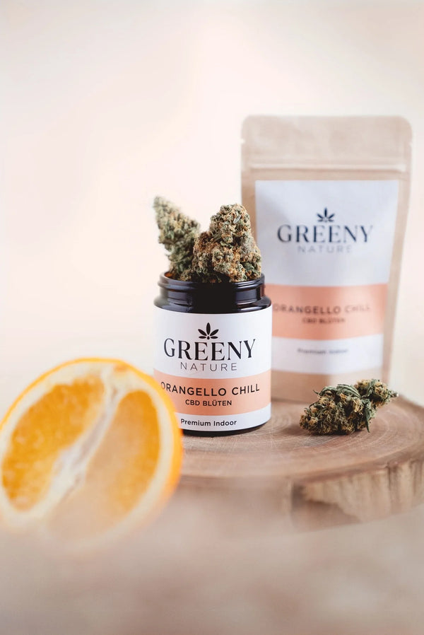 Orangello Chill CBD Blüten im geöffneten Glastiegel mit Standbeutel und Orangenscheibe